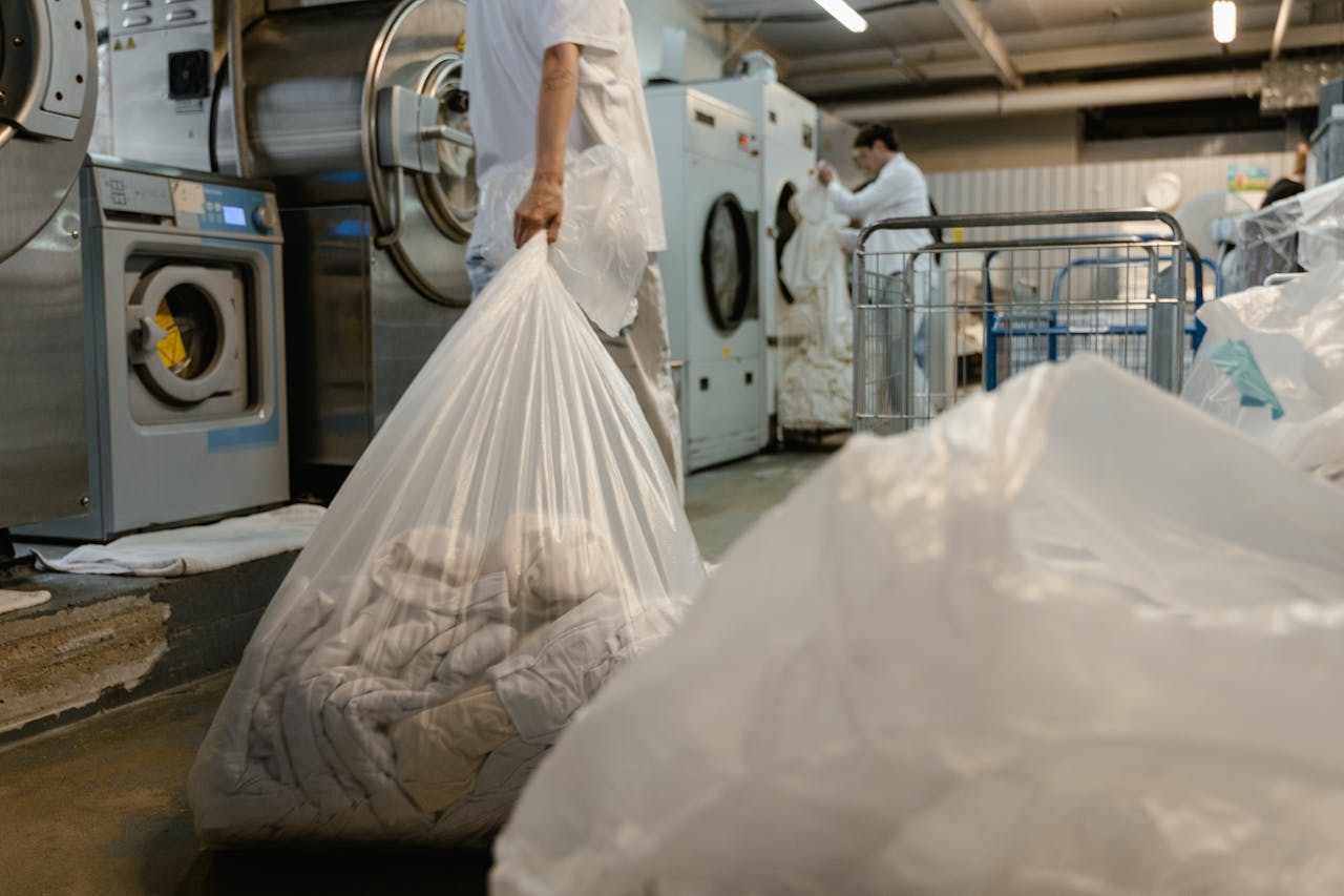 Inicio Person carrying laundry bag in a commercial laundry facility.